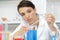 Positive minded woman adding chemical liquid in lab