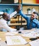 Positive multicultural office employees in shirts giving five each other for successful collaboration