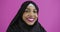 Positive Muslim woman wearing Muslim hijab over colorful background