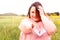 Positive obese woman smiling outdoors. Looking and pointing at the camera. Selective Focus. Copy space. Front view. chubby