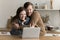 Positive overjoyed young husband and wife hugging at laptop