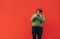 Positive overweight man and green sweatshirt funny dancing on red wall background and smiling. Fat man shows a dance performance.