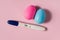 A positive pregnancy test on a pink background and pink and blue eggs, determining the gender of the unborn child.