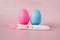 A positive pregnancy test on a pink background and pink and blue eggs, determining the gender of the unborn child.