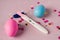 A positive pregnancy test on a pink background and pink and blue eggs, determining the gender of the unborn child.