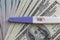 A positive pregnancy test on the US dollars background