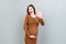 positive pregnant woman showing okay gesture against her belly at colored background. Easy and happy pregnancy. Copy