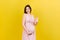 Positive pregnant woman showing okay gesture against her belly at colored background. Easy and happy pregnancy. Copy space