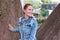 Positive redhead Caucasian woman posing at tree in park at autumn looking away