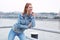 Positive redhead woman looking away at riverbank