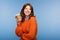 positive redhead woman in orange sweater