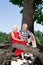 Positive retired couple sitting on the old tree and smiling happily