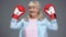Positive retiree woman in boxing gloves rising hands up, success concept, belief