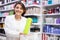 Positive salesgirl helping to choose hair products in cosmetic store