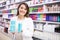 Positive salesgirl helping to choose hair products in cosmetic store