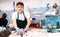 Positive salesman demonstrating sole fish behind counter in shop