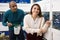 Positive salesman helping woman choosing aquarium fish