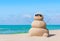 Positive sandy snowman in sunglasses at sunny ocean tropical beach