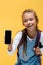 Positive schoolkid holding backpack and smartphone