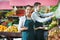 Positive sellers having vegetables and fruits on displays