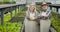 Positive senior Caucasian woman and man giving high five, looking at camera and smiling. Cheerful professional farmers