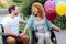 Positive senior wheelchaired couple resting in the park