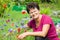 Positive senior woman sitting among flowers in a garden