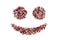 Positive smiley emoticon made of dried rose petals on a white background