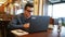 Positive smiling caucasian man in glasses talking on video conference call chat with a laptop in cafe. Speaker holds