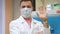 Positive smiling researcher in laboratory looking at camera and waving right hand showing greeting