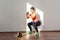 Positive sportive woman with bun hairstyle and in tight sportswear doing squatting. indoor studio shot illuminated by sunlight