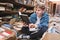 Positive student sitting on the floor in an old public library and reading books