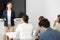 Positive successful woman near interactive board conducting business training for audience in classroom