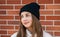 positive teenager girl wearing hat. photo of teenager girl outside. teenager girl on brick