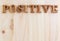 positive text on wooden background