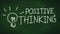 Positive thinking concept. handwritten word positive thinking on black chalkboard with light bulb as idea