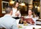 Positive waitress taking table order