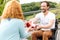 Positive wheelchaired senior man giving a present to his wife