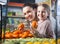 Positive woman and blonde little girl posing whith mandarin in d