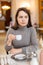 Positive woman enjoying cup of delicious espresso in cafe