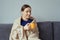 Positive woman enjoying a cup of tea wrapped in a blanket