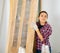 Positive woman installs a new wooden door herself in apartment