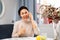 Positive woman sitting at table and having telephone conversation