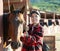 Positive woman stable worker combing and cleaning horse of dirt with brush. Horse care, love for animals concept