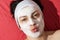 Positive woman with white smoothing face mask sending kiss