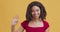 Positive young african american woman waving hand to greet