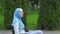 Positive young disabled woman in a Muslim hijab stroller on a walk in the Park