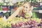 Positive young female seller holding bunch of grapes on market