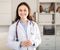 Positive young female trainee doctor stands in a welllit resident's office