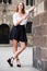 Positive young girl standing near the stone wall